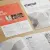 Printed startup materials including business cards, flyers and booklets laid out on a minimalist office desk